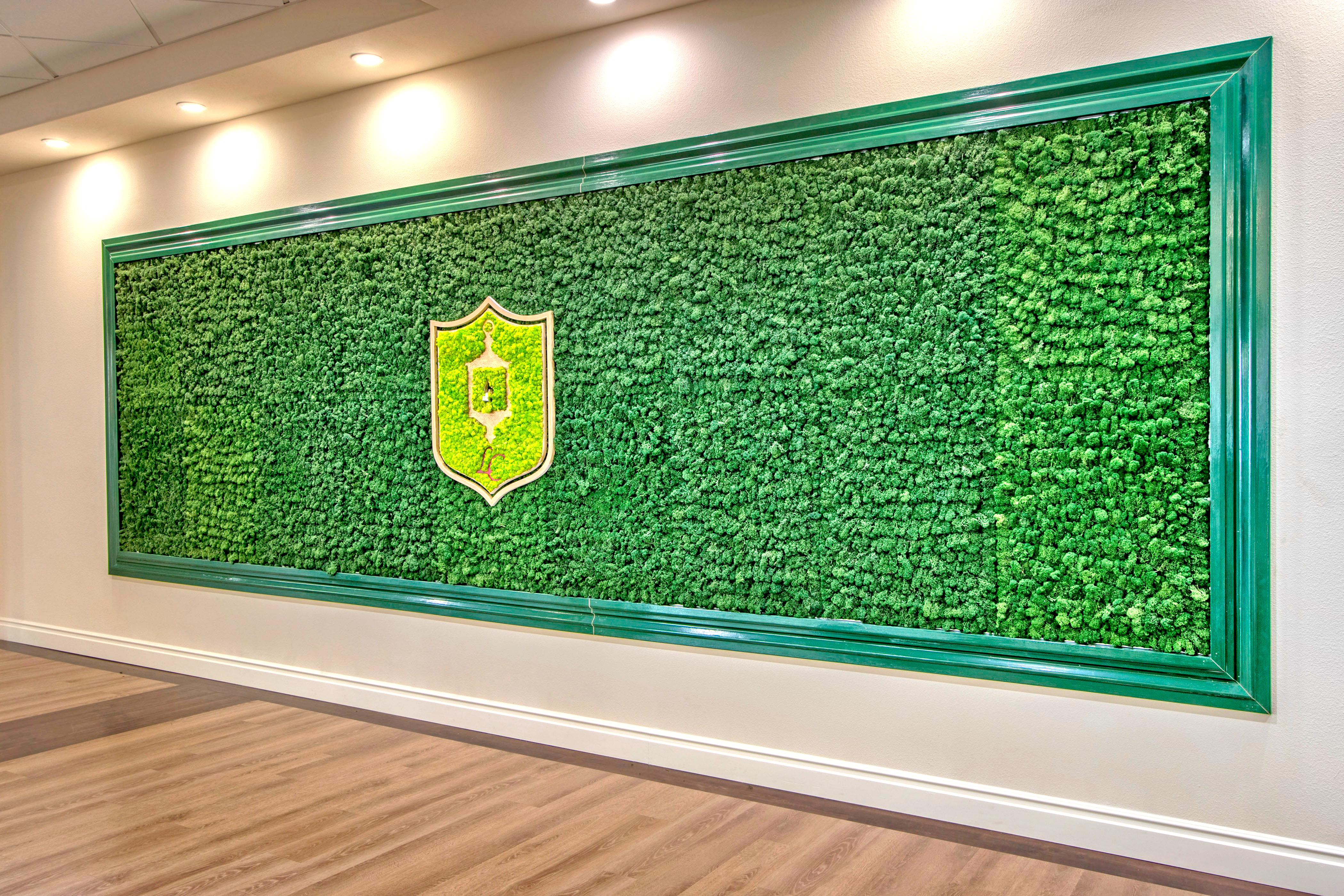 A living moss wall with Lantern Crest's insignia in the middle