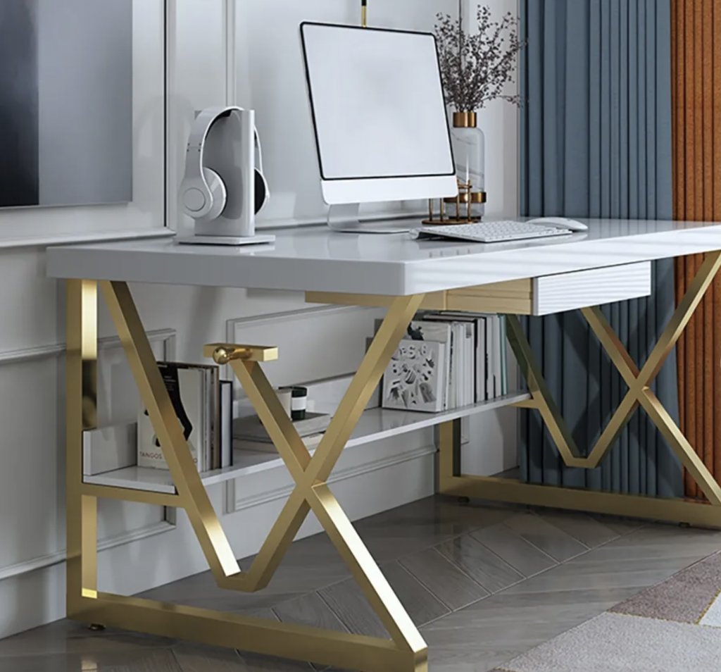 A work from home office with a white marble desk and gold intricate legs